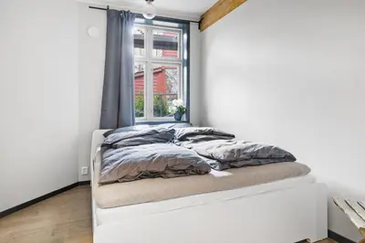 a white bed in a room with a window at Elegant Urban Apartment in Bergen
