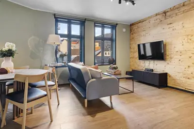 a living room with a table and chairs and a tv at Elegant Urban Apartment in Bergen