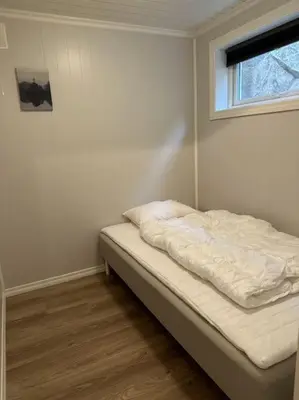 an unmade bed in a room with a window at Rorbu i Gilsvågen - 3 soverom - Båtutleie in Austevoll