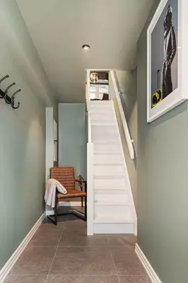 a staircase in a room with a chair and a stair case at Bryggen // Fløyen Apartments in Bergen