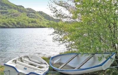 two boats sitting on the shore of a lake at Holiday Home Sandeid Ilsvåg in Sandeid