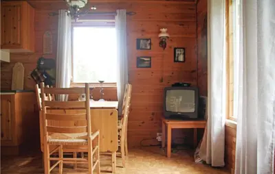 a dining room with a table and a television at Holiday Home Sandeid Ilsvåg in Sandeid