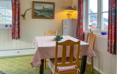 a dining room table with a pink table cloth and chairs at 2 Bedroom Lovely Home In Innfjorden in Innfjorden