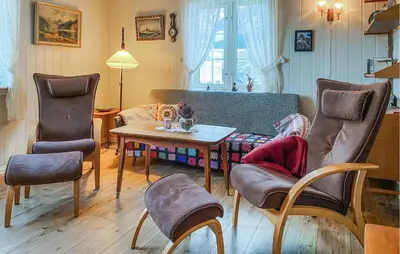 a living room with a couch and a table and chairs at 2 Bedroom Lovely Home In Innfjorden in Innfjorden