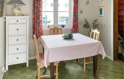 a dining room table with a pink table cloth on it at 2 Bedroom Lovely Home In Innfjorden in Innfjorden