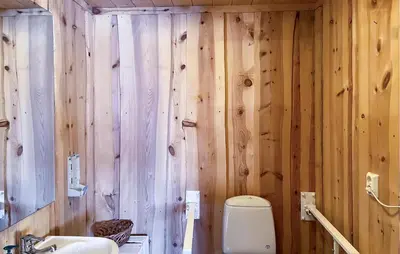 a wooden bathroom with a toilet and a sink at 6 Bedroom Cozy Home In Kvam in Kvam