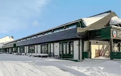 a building with benches in the snow next to a street at Gorgeous Apartment In Kvam With Sauna in Kvam