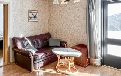 a living room with a leather couch and a table at Gorgeous Apartment In Kvam With Sauna in Kvam