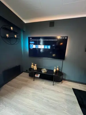 a living room with a large flat screen tv on the wall at Rjukan Sentrum Apartments NO 1 in Rjukan