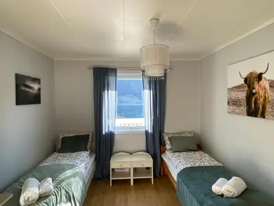 a bedroom with two beds and a window at Honey bay cottage in Stadlandet