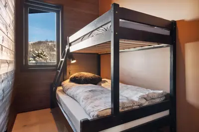 a bunk bed in a room with a window at Riddergaardens utsikt in Beitostøl