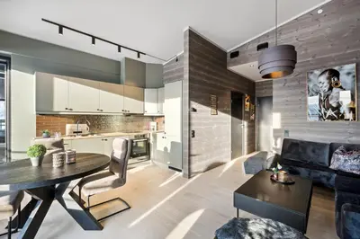 a kitchen and living room with a table and a couch at Riddergaardens utsikt in Beitostøl