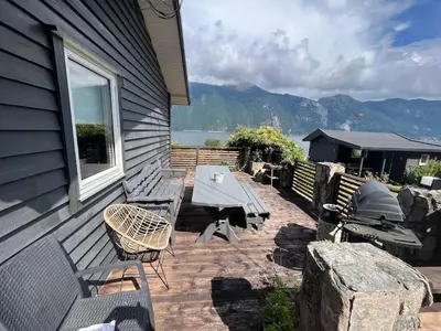 a patio with a picnic table and a table and chairs at Cabin by the Fjord in Øksendalsøra