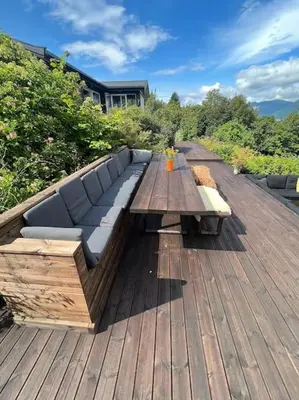 a couch sitting on top of a wooden deck at Cabin by the Fjord in Øksendalsøra