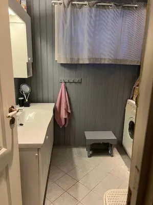 a bathroom with a sink and a washing machine at Cabin by the Fjord in Øksendalsøra
