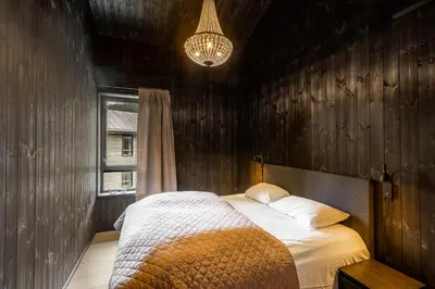 a bedroom with a bed with a wooden wall at Vister, Hemsedal - fine leiligheter rett ved Fyri Resort - Ski inn - Ski out in Hemsedal