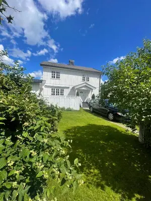 a car parked in front of a white house at Familievennlig fritidsbolig i hjertet av Flå, perfekt for besøk i Bjørneparken in Flå