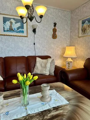 a living room with a couch and a table with yellow flowers at Familievennlig fritidsbolig i hjertet av Flå, perfekt for besøk i Bjørneparken in Flå