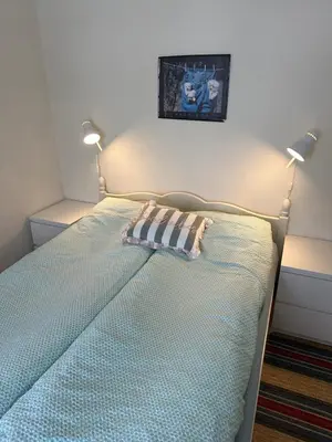 a bedroom with a bed with two lamps on it at Familievennlig fritidsbolig i hjertet av Flå, perfekt for besøk i Bjørneparken in Flå