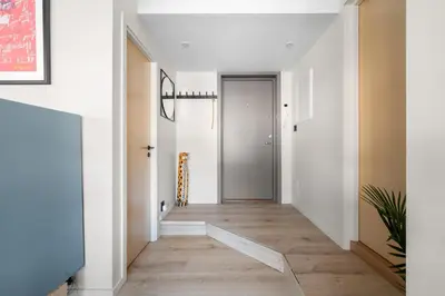 a hallway with white walls and a wooden floor at Nordnes - Amazing view of Bryggen! in Bergen