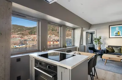 a kitchen and living room with a view of a city at Nordnes - Amazing view of Bryggen! in Bergen
