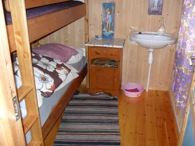 a small bedroom with a bunk bed and a sink at Orset setra - back to basic cabin - with amazing view in Torvikbukt