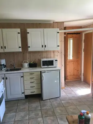 a kitchen with white cabinets and a white microwave at Rønlund Hyttepark, Midgard in Ron