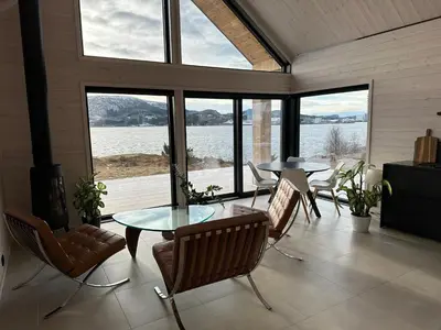 a living room with a glass table and chairs at Brattøya sjøstuer in Kristiansund