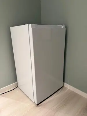 a white refrigerator in the corner of a room at Cozy basement apartment in Orkanger in Orkanger
