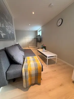 a living room with a couch and a table at Cozy basement apartment in Orkanger in Orkanger