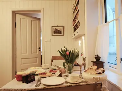 a table with plates of food and flowers on it at Unikt og romslig hus perfekt for grupper in Nordfjordeid