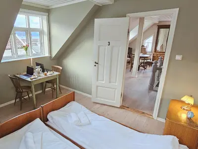 a bedroom with a bed and a desk and a table at Unikt og romslig hus perfekt for grupper in Nordfjordeid