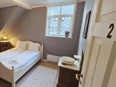 a small bedroom with a bed and a window at Unikt og romslig hus perfekt for grupper in Nordfjordeid