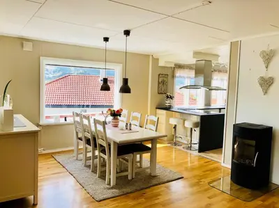 a kitchen and dining room with a table and chairs at Solrikt og sentralt. Ta med både to og firbeinte in Lillehammer