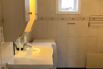 a white bathroom with a sink and a mirror at Solrikt og sentralt. Ta med både to og firbeinte in Lillehammer