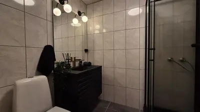 a bathroom with a shower and a toilet and a sink at Moderne cityleilighet Sogndal in Sogndal
