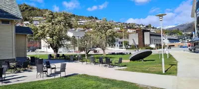 a group of chairs and tables in a park at Moderne cityleilighet Sogndal in Sogndal
