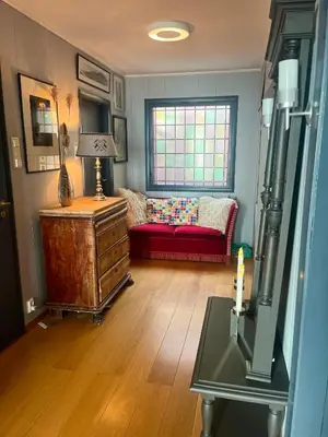 a living room with a red couch and a window at Villa med panoramautsikt, stor uteplass og 100 m fra badestrand in Bergen