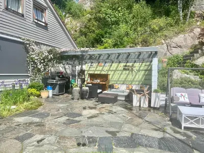a patio with a fireplace in a house at Villa med panoramautsikt, stor uteplass og 100 m fra badestrand in Bergen
