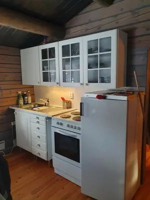 a kitchen with white cabinets and a white refrigerator at Bjørgebu Camping AS in Mysusæter