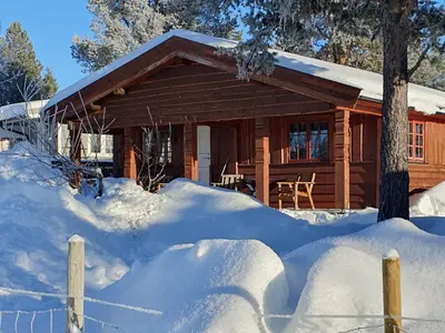 a log cabin in the snow with a fence at Bjørgebu Camping AS in Mysusæter