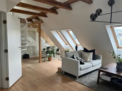 a living room with a white couch and wooden floors at Vaskerelven 4 in Bergen