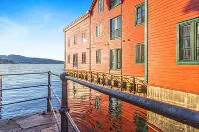 an orange building next to a body of water at Seaside Apt. Catch Crabs from Your Bedroom Window! in Bergen