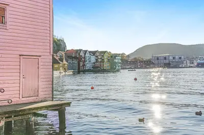 a house sitting on a dock in a body of water at Seaside Apt. Catch Crabs from Your Bedroom Window! in Bergen