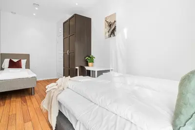 a white bedroom with a bed and a chair at Ocean-view Haven: Take a swim from your window! in Bergen