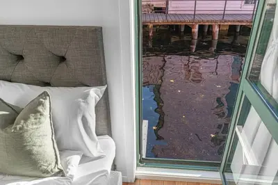 a window with a couch and a view of the water at Ocean-view Haven: Take a swim from your window! in Bergen