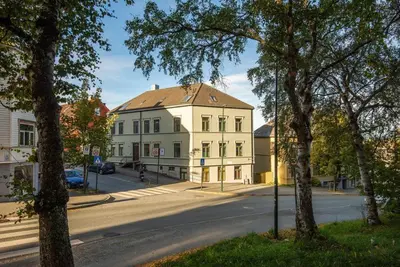 a large white building on a street with trees at City View & Central Location in Trondheim