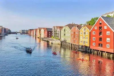 a river with colorful buildings and boats in the water at City View & Central Location in Trondheim