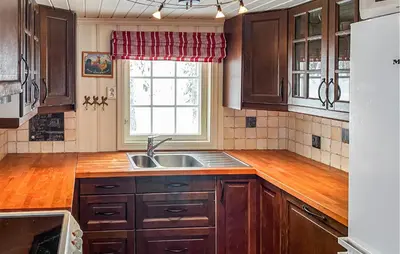 a kitchen with wooden cabinets and a sink and a window at Nice Home In Gol With Kitchen in Golsfjellet