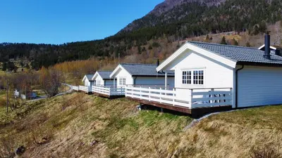 a row of houses on a hill with a mountain at Gjerdset Turistsenter in Isfjorden